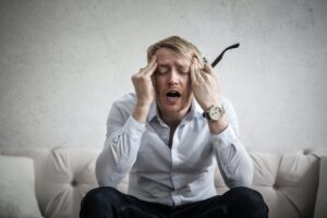 man in pain holding head